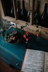 Vertical view looking down at an open book of classical sheet music resting on a distressed teal wooden cabinet.